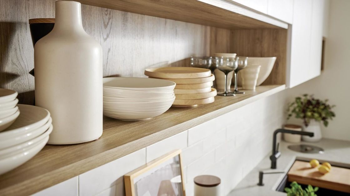 Volledige moderne keukenkasten met kwartssteen aan tafel en houten pantryopslag