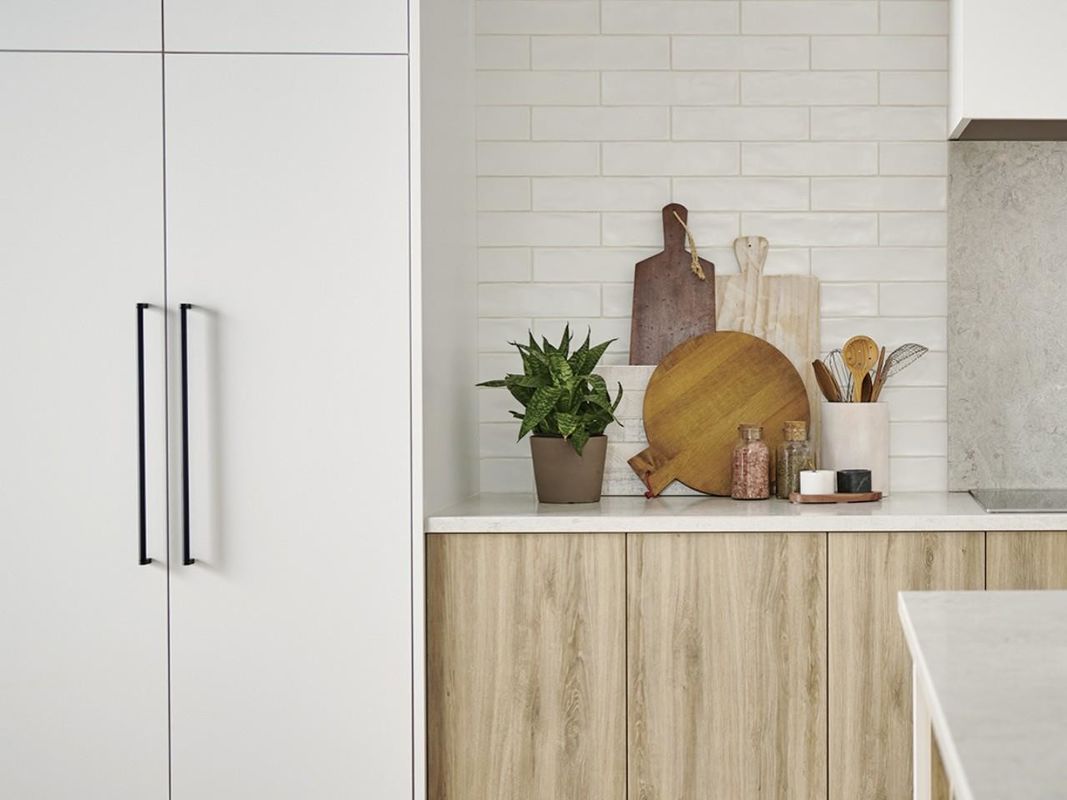 Volledige moderne keukenkasten met kwartssteen aan tafel en houten pantryopslag