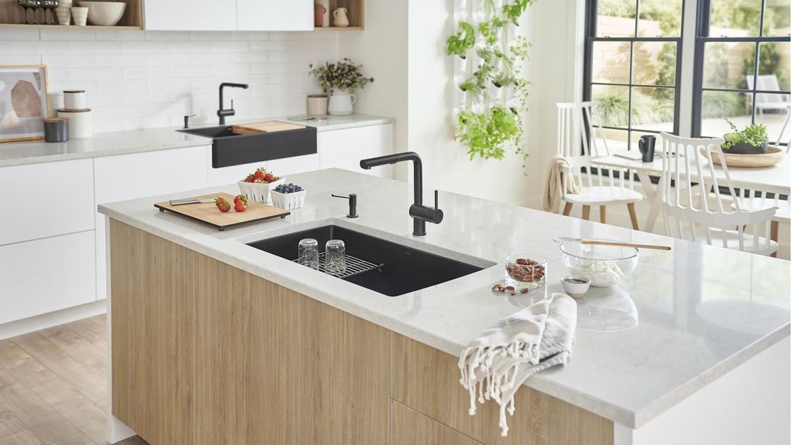 Volledige moderne keukenkasten met kwartssteen aan tafel en houten pantryopslag