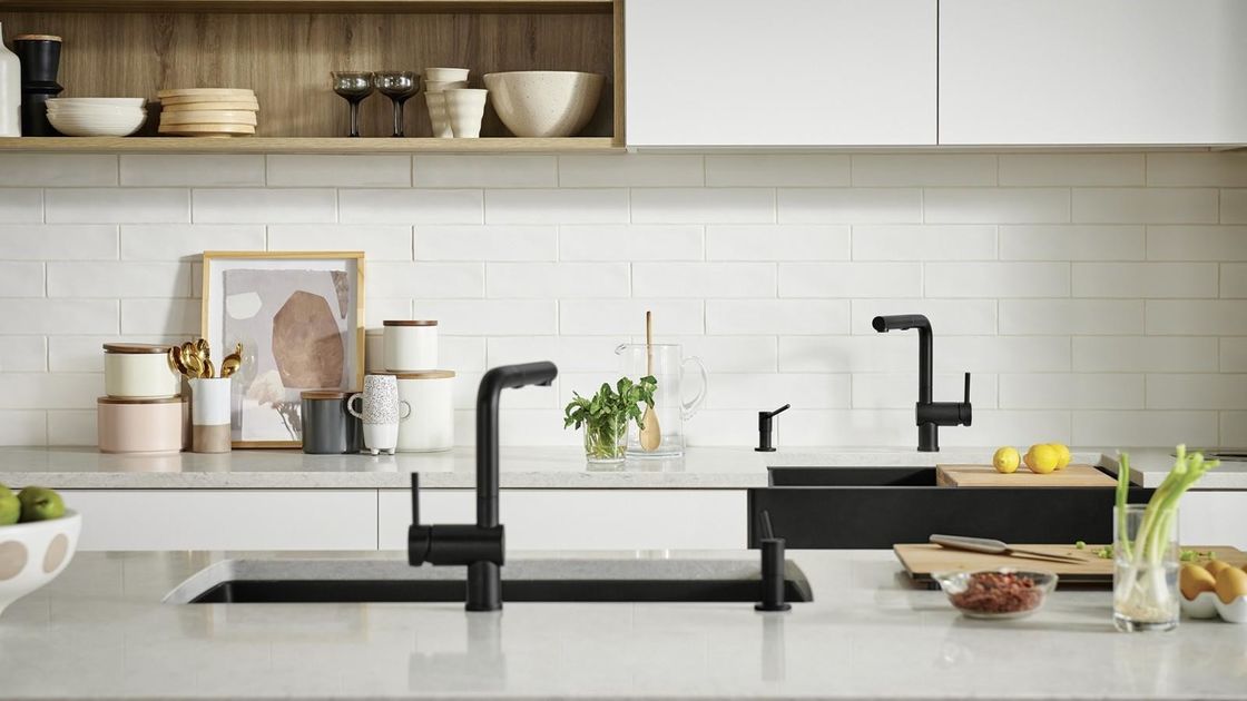 Volledige moderne keukenkasten met kwartssteen aan tafel en houten pantryopslag